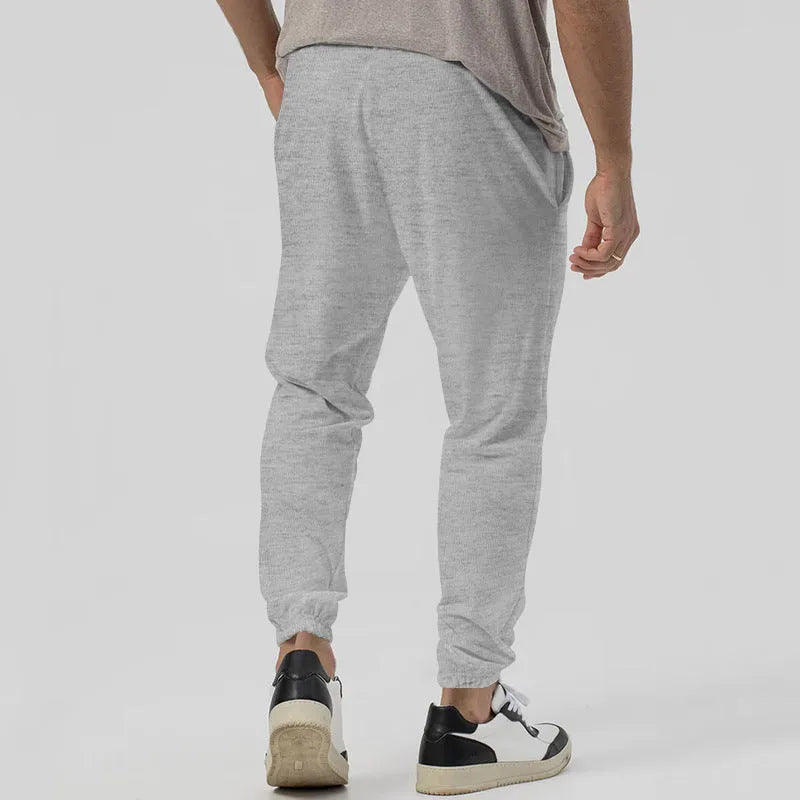 Men's casual track sweatpants in loose tapered straight-leg design showing army green colour option
