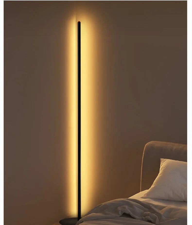Simple modern vertical aluminium alloy floor lamp in silver, shown beside a sofa.