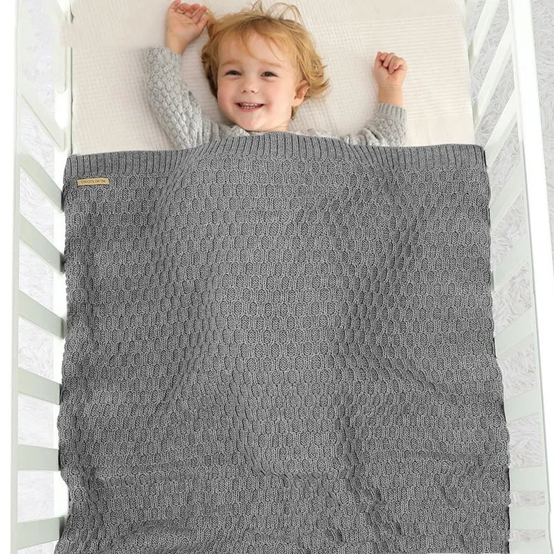 Solid colour infant hug blanket with textured lines in acrylic fabric, measuring 70 by 90 centimetres