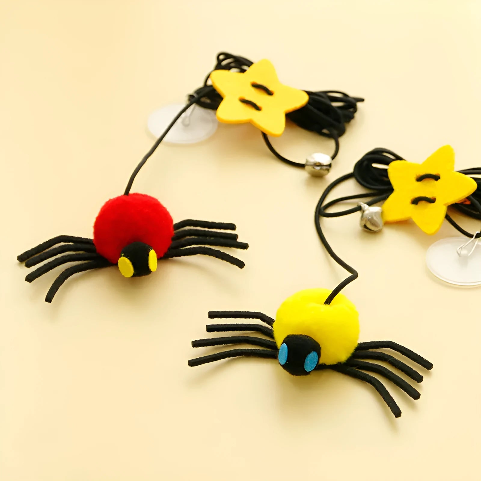 Red and yellow hanging cat toy with elastic rope, feather, bell, and spider elements for door mounting